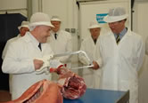 Plant manager Vic Dawes gives Prince Charles a carcase cutting demonstration.
